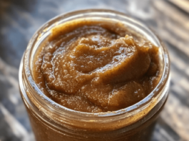 Apple Butter A close-up shot of a clear glass jar filled with homemade apple butter, revealing its thick, smooth texture and rich brown color.